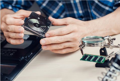 Engineer holding an opened hard drive in the lab